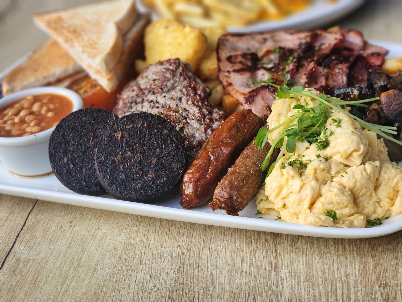 Big breakfast plate with bacon, eggs, sausage, black pudding and toast