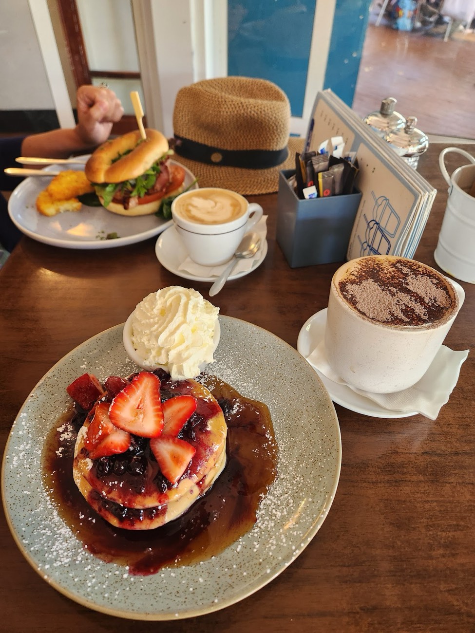Hotcakes with berries and cream, a latte and a hot chocolate